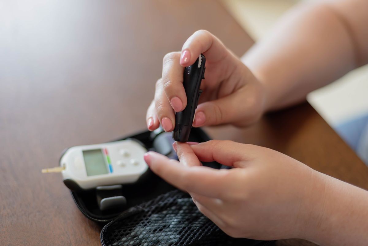 Woman uses glucose meter to monitor diabetes