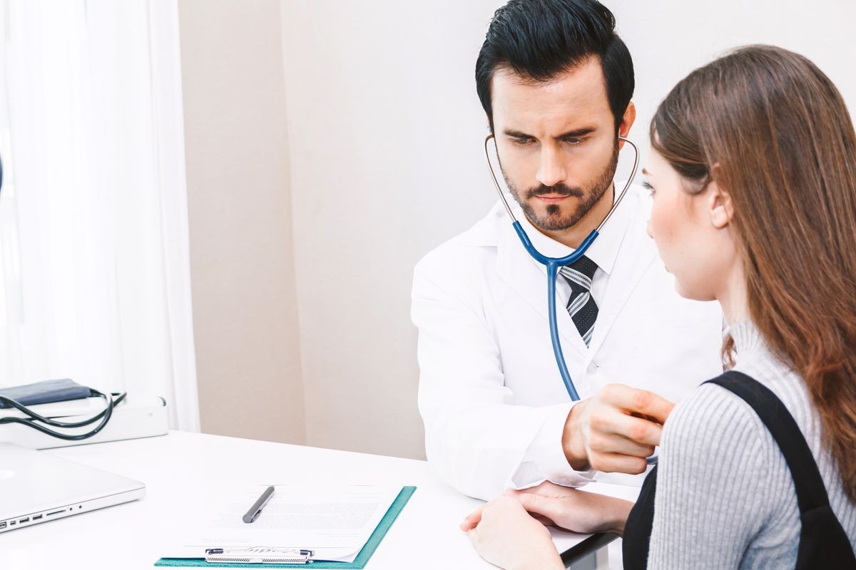 Doctor examining female patient in hospital