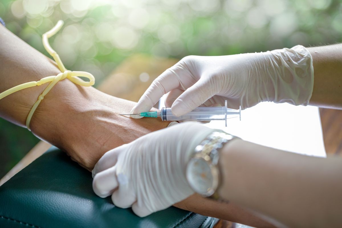 Nurse collecting a sample blood from a patient,Nurse swabbing is pressed onto the injection site.